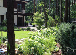 Zlokalizowany pod Warszawą leśny ogród, zaprojektowany przez Ninę Klejnowską-Matacz
i Piotra Matacza ze studia Garden & Pleasure Pracownia Sztuki Ogrodowej, jest przestrzenią, w której dominują elementy drewniane i naturalny kamień, tworzące harmonijną całość z otaczającym posesję lasem. Naturalistyczny styl leśnego ogrodu jest wyraźnie zintegrowany z otaczającą go przyrodą.

