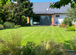 Ogród zaprojektowany przez studio AddGreen Architektura Krajobrazu jest przestrzenią prostą i uporządkowaną, z wyraźnym akcentem minimalistycznym. Cały projekt opiera się na oszczędnym wykorzystaniu przestrzeni, gdzie każdy element został dokładnie przemyślany i dopasowany. Wyraźnie zaznaczonym elementem ogrodu jest trawnik, zajmujący sporą część terenu, tworzący jednolitą, zachęcającą do rekreacji powierzchnię. Rabaty są zaplanowane i rozmieszczone symetrycznie, co nadaje całości eleganckiego i uporządkowanego charakteru.