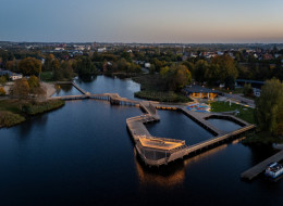 Plaża miejska nad jeziorem Niskie Brodno to przykład innowacyjnego podejścia do kształtowania nadwodnych przestrzeni publicznych. Kompleksowa rewitalizacja obejmowała zarówno modernizację istniejącej infrastruktury, jak i wprowadzenie nowych elementów funkcjonalnych i rekreacyjnych, tworząc spójny projekt odpowiadający potrzebom różnych grup użytkowników.