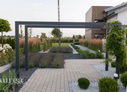 Mocno kontrastująca z ogrodową zielenią biel stała się jednym z głównych motywów nowoczesnego ogrodu w bieli zaprojektowanego przez Dagmarę Berent ze studia AureaGarden. Spora przestrzeń została skomponowana w taki sposób, aby znalazło się na niej miejsce zarówno na dużą ilość nasadzeń, jak i na wypoczynek lub rekreację. Całość utrzymana jest w estetycznym minimalizmie.