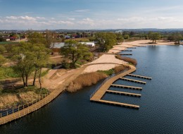 Przestrzeń dobrze znana mieszkańcom Krakowa po niedawno zakończonej modernizacji została uporządkowana i stała się miejscem bezpiecznym, służącym wypoczynkowi i rekreacji. Modernizacja kąpieliska w Przylasku Rusieckim to przede wszystkim nowe ścieżki spacerowe, pomosty, zabezpieczenie zbiorników wodnych i stworzenie zaplecza sanitarno-gospodarczego. Projekt modernizacji kąpieliska stworzyła firma Saneccy sp. z o.o., a za jego wykonanie odpowiada Krisbud sp. z o.o.