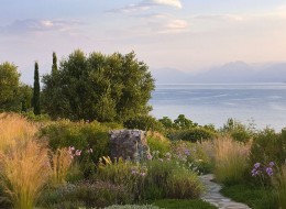 Greckie krajobrazy zachwycają, jednak tamtejszy klimat nie jest łaskawy dla miłośników ogrodnictwa. Do najbardziej sprzyjających obszarów zalicza się wyspę Korfu – dowodem na to jest ogród zaprojektowany wokół wakacyjnych posiadłości na wynajem