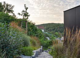 Projekt nowoczesnego domu jednorodzinnego w dolinie Krasu Morawskiego w Czechach to przykład połączenia architektury z naturalnym otoczeniem. Dom wzniesiony na stromej działce stanowi wyzwanie zarówno dla projektantów, jak i wykonawców, ze względu na trudny teren i konieczność odpowiedniego dostosowania konstrukcji do specyficznych warunków geograficznych. Projekt widokowego ogrodu rozciągającego się wokół domu przygotował zespół architektów z Atelier Partero.