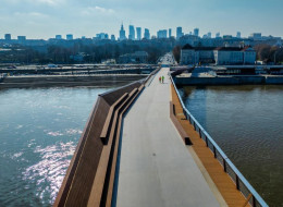 Warszawa powitała nowy element swojej urbanistycznej przestrzeni - rdzawą kładkę dla pieszych. Ta niepozorna konstrukcja, oddana do użytku bez wielkich uroczystości 28 marca 2024 roku, stanowi nie tylko praktyczny dodatek do infrastruktury miasta, ale stała się też zarzewiem emocjonalnych dyskusji. Czy kładka rzeczywiście łączy, czy może nieoczekiwanie dzieli społeczność Warszawy? Jak nowa konstrukcja wpływa na codzienne życie miasta i jego mieszkańców ? 